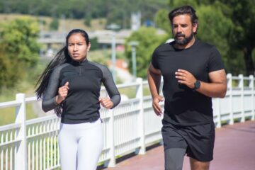 Casal correndo em uma pista de atletismo no inverno